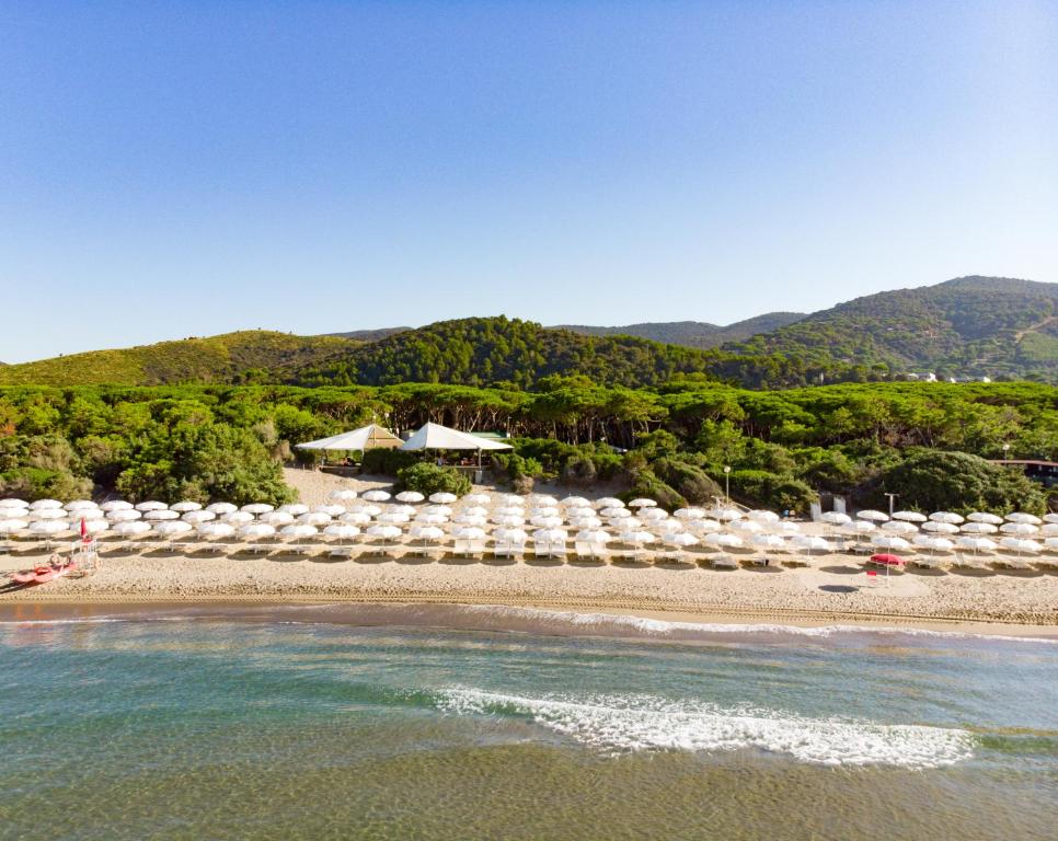 een strand met parasols en stoelen en de oceaan bij Riva Del Sole Resort & SPA in Castiglione della Pescaia