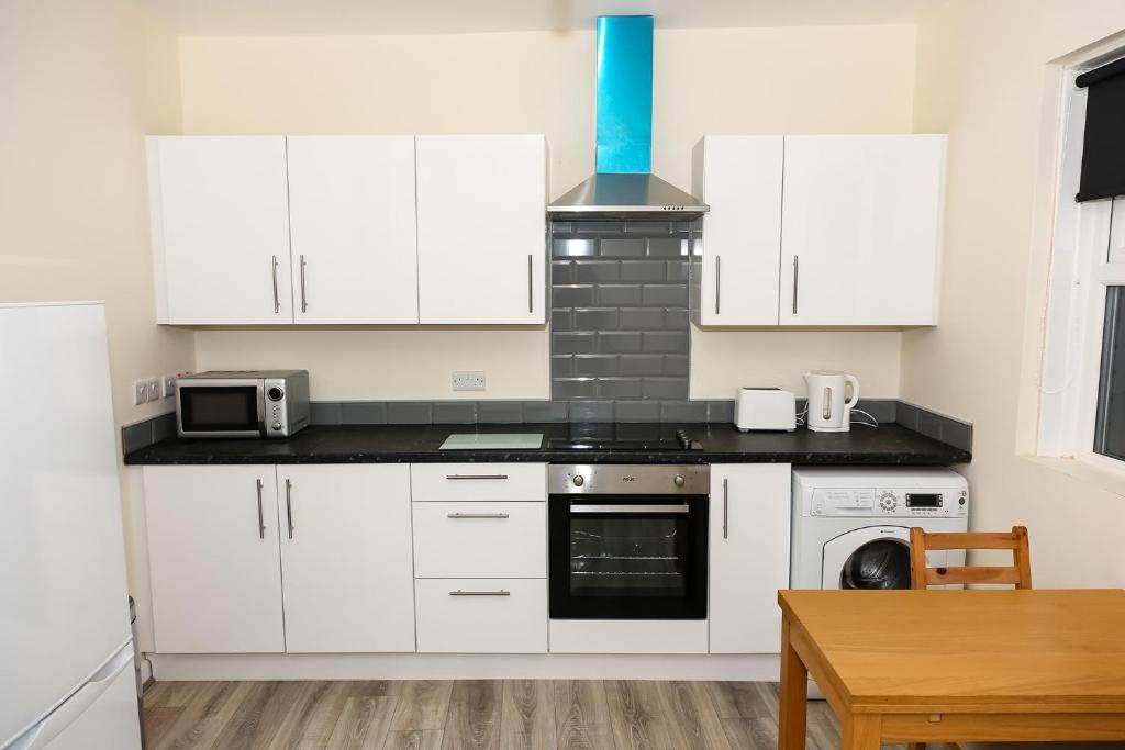 a kitchen with white cabinets and a stove top oven at AA Sunderland North in Sunderland