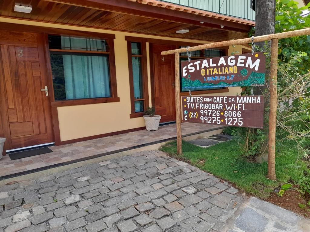 a sign in front of a house with a building at Estalagem O Italiano in Lumiar