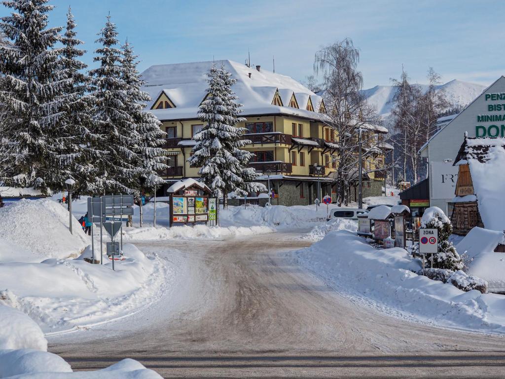 a road covered in snow in front of a building at Apartment Peter in Donovaly