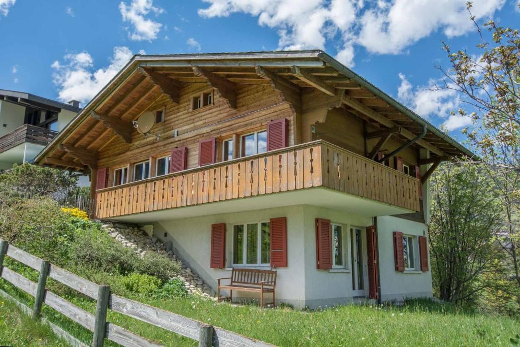 a house with a balcony on top of a hill at Chalet Falki in Adelboden