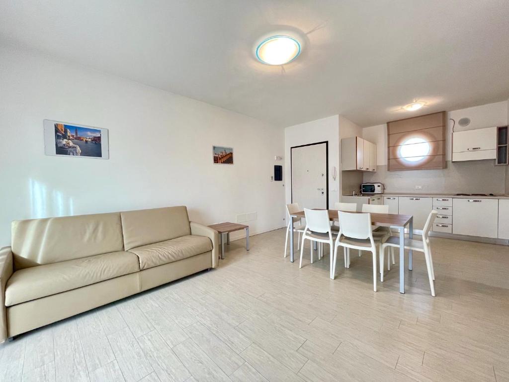 a living room with a couch and a table and chairs at Residence Treporti - Carraro Immobiliare - Family Apartments in Cavallino-Treporti