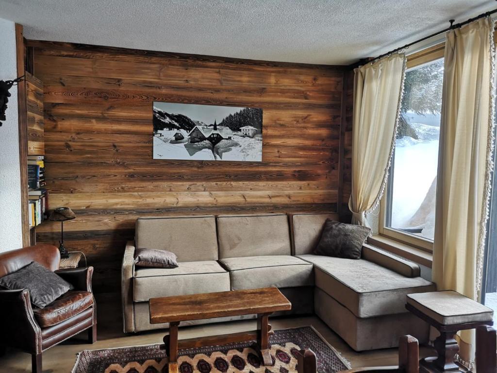 uma sala de estar com um sofá e uma mesa em Appartamento em Madonna di Campiglio