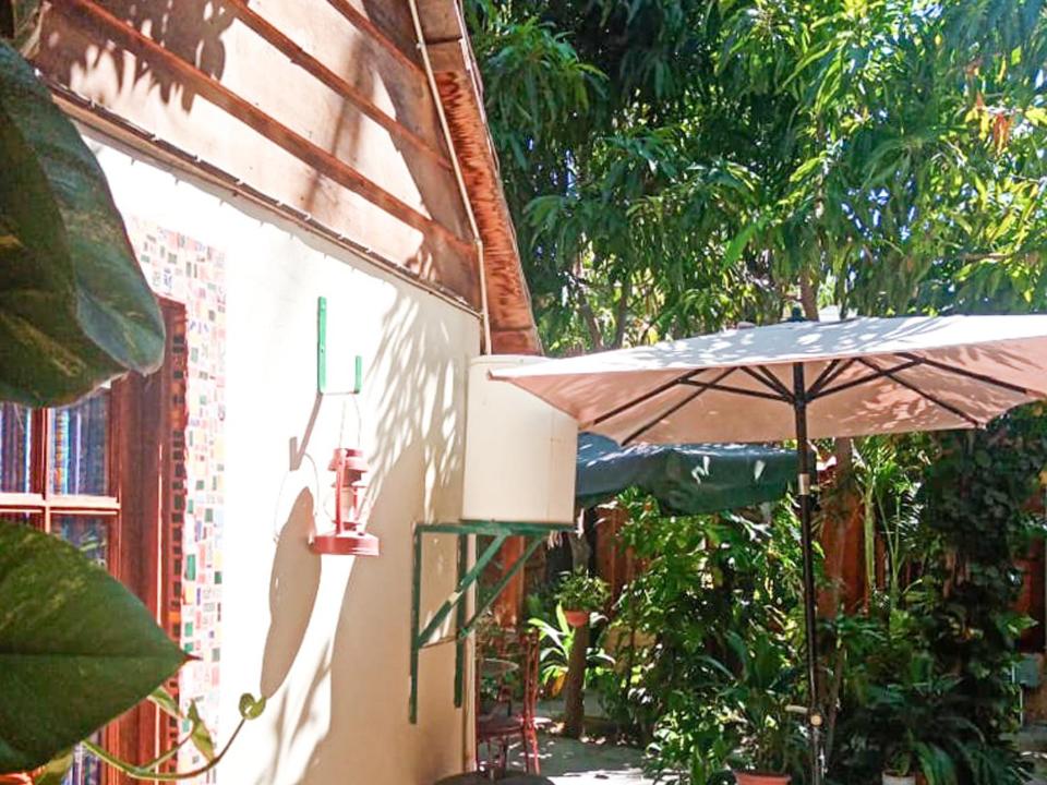 eine Terrasse mit einem Sonnenschirm und einem Sonnenschirm in der Unterkunft Cabañas Rústicas El Benny by Rotamundos in Loreto