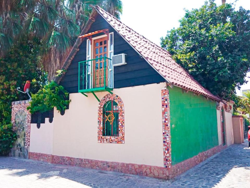 una pequeña casa con un verde y blanco en Cabañas Rústicas El Benny by Rotamundos, en Loreto
