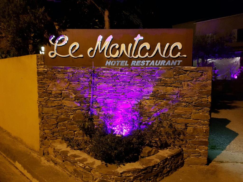 un panneau indiquant un restaurant de l'hôtel avec des lumières violettes dans l'établissement Auberge le Montana, à Saint-Florent