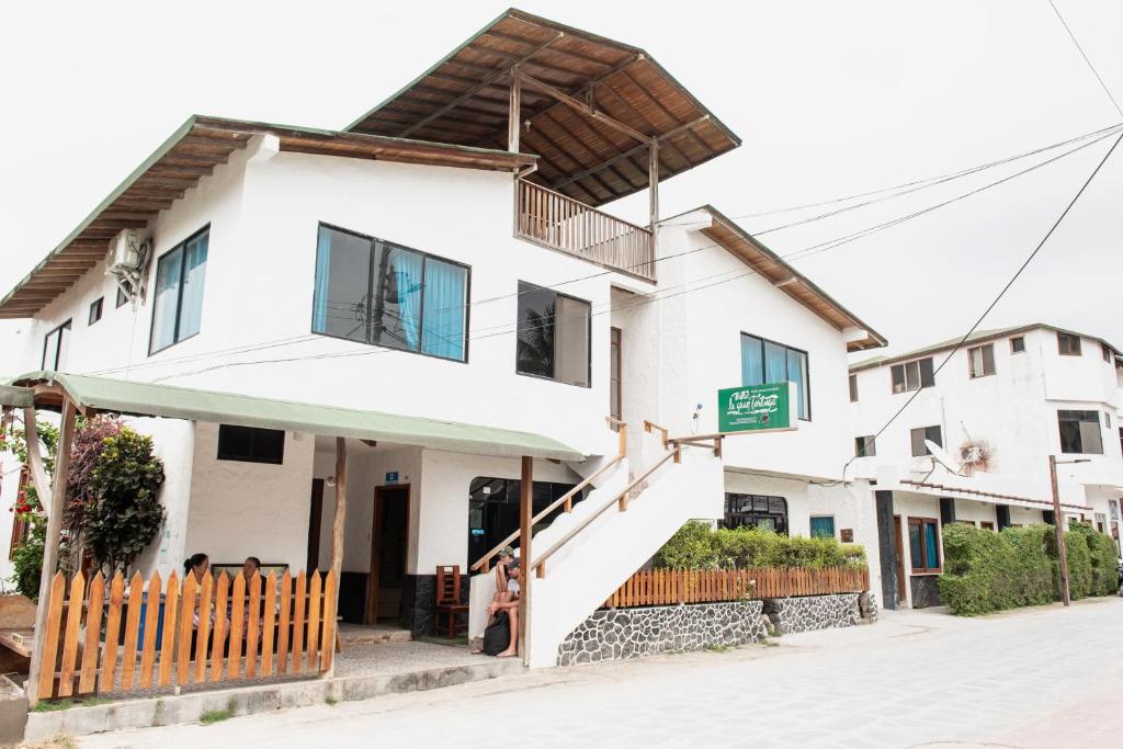 una casa blanca en la esquina de una calle en Hotel LA GRAN TORTUGA - ᯤ STARLINK, en Puerto Villamil