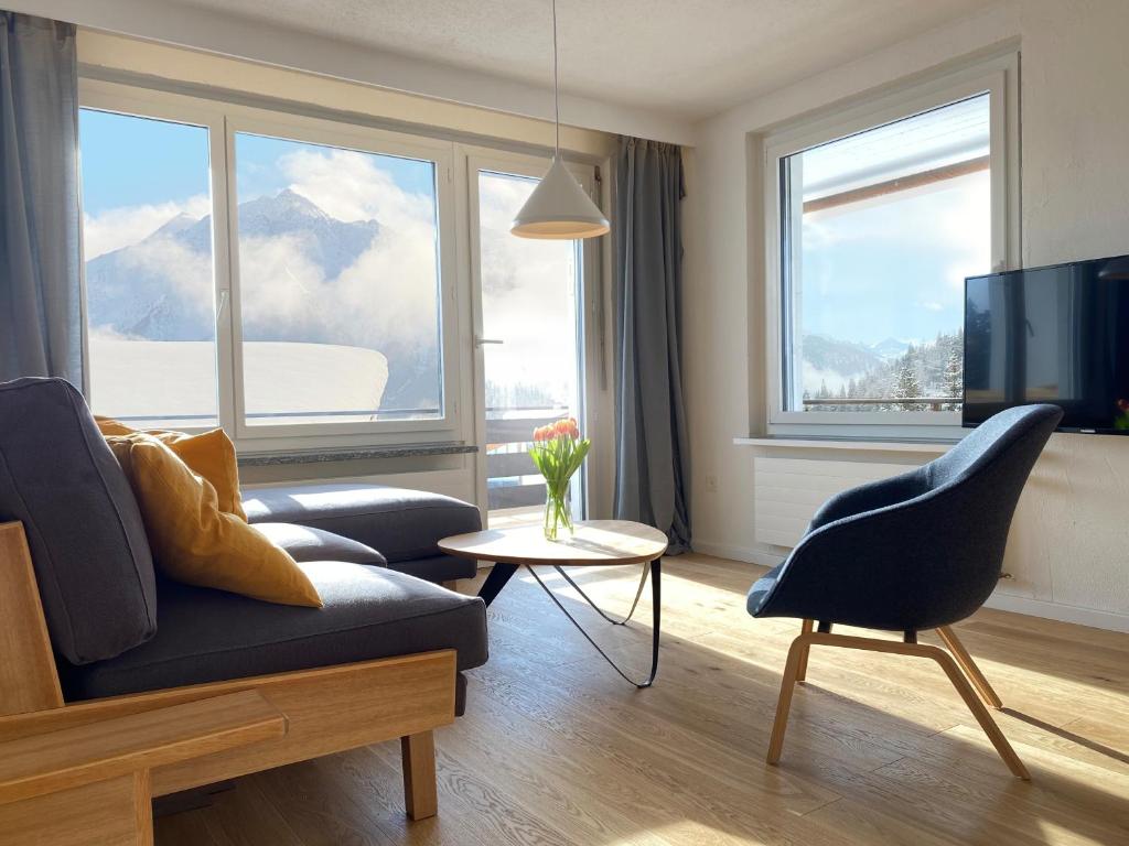 un soggiorno con divano e TV di Grüezi Laax Apartments a Laax