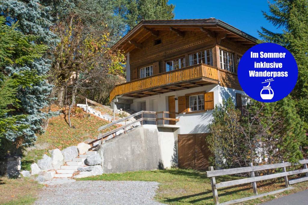 une maison avec un panneau devant elle dans l'établissement Chalet Pavillon, à Adelboden