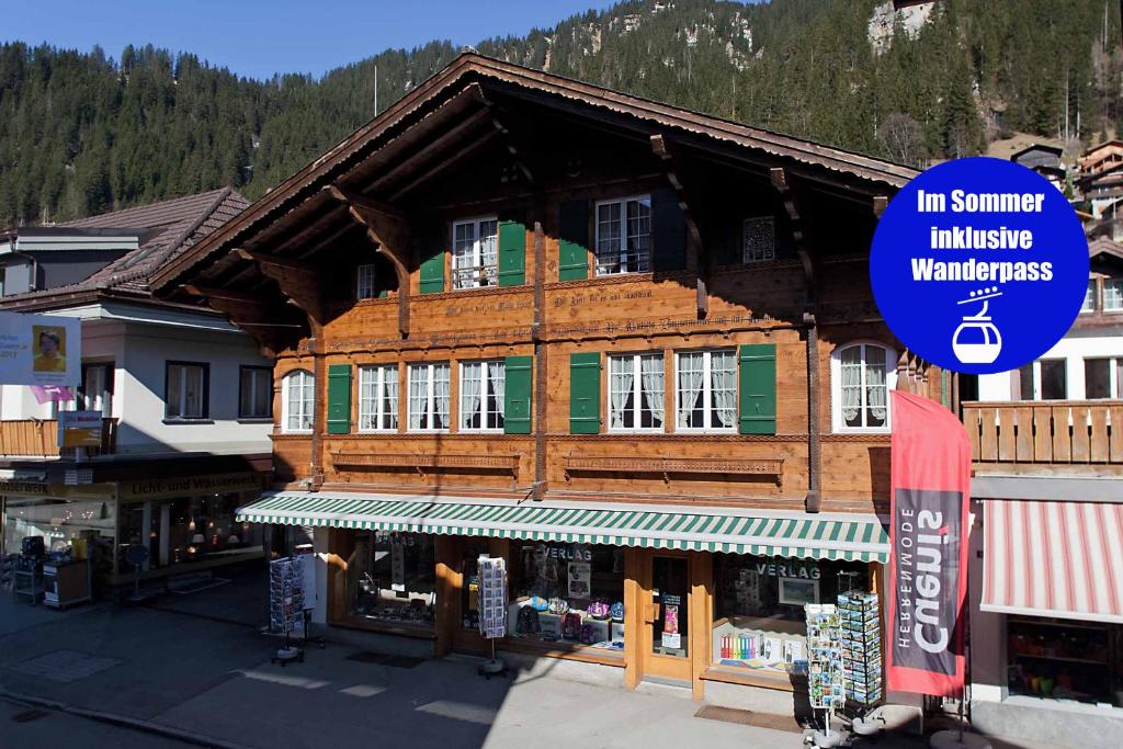 un grande edificio in legno con un cartello sopra di Im Zentrum ad Adelboden