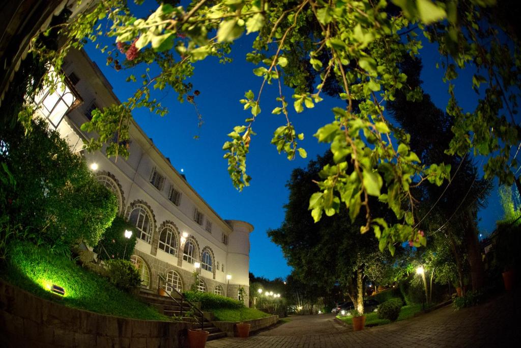 um edifício numa rua à noite com luzes em Hotel Casacurta em Garibaldi