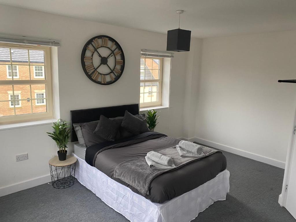 um quarto com uma cama e um relógio na parede em Doncaster Furnished House For Short Lets em Mexborough