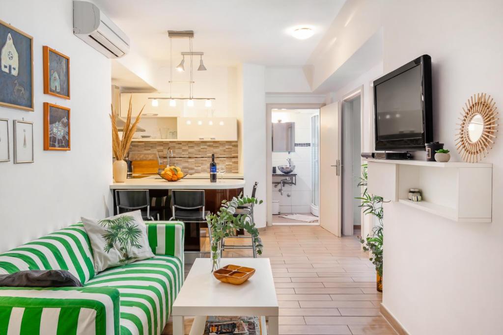 a living room with a green couch and a kitchen at Apartment Spalatin in Split