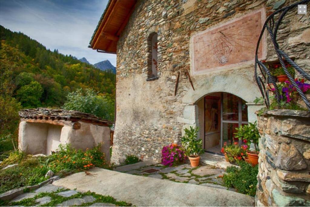 a stone building with flowers in front of it at La casa di Chiara in Marmora