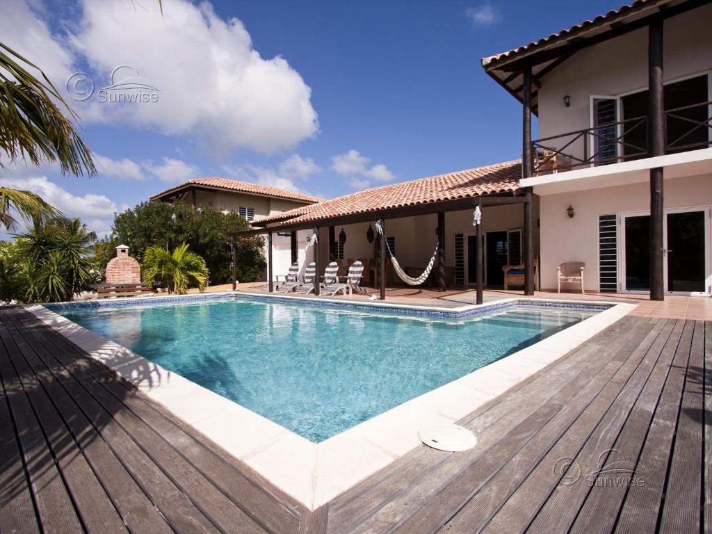 a villa with a swimming pool and a house at Kas Vis in Kralendijk