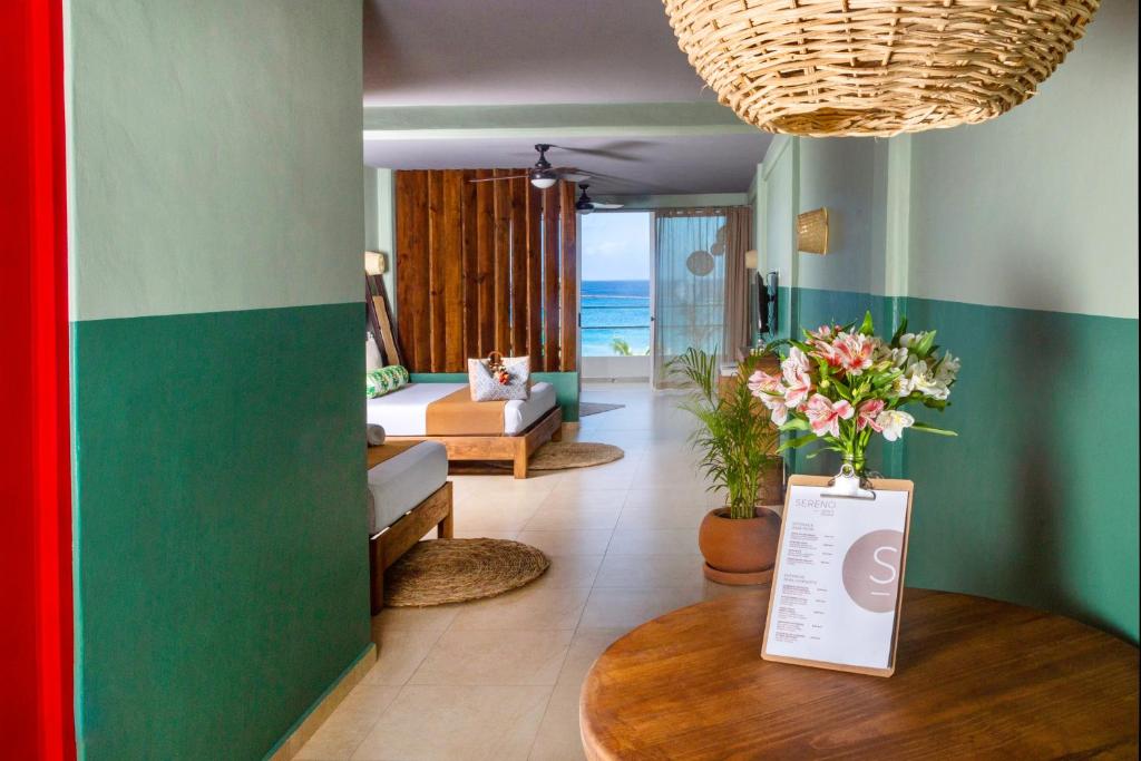 a living room with a couch and a table with flowers at Albatros Suites by Bedsfriends in Cozumel