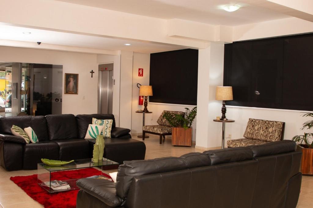 a living room with a leather couch and chairs at Corumbá Plaza Hotel in Luziânia