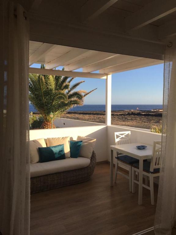 a living room with a couch and a table and the ocean at Blu Oceano in Teguise