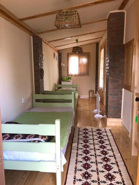 a bedroom with two bunk beds and a rug at Salaš Gnijezdo in Bačka Palanka