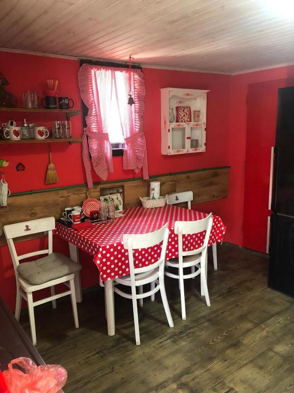 a red dining room with a table and chairs at Salaš Gnijezdo in Bačka Palanka