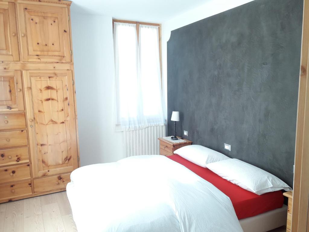 a bedroom with a bed and a large window at Appartamenti Via Monte Braulio 19 in Bormio