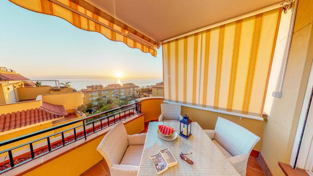a balcony with a table and chairs and a view of the ocean at Casa Tres Vistas Luxury apartment with stunning views to the ocean in Puerto de Santiago