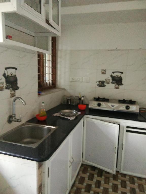 a kitchen with a sink and a stove at Nunu Homestay Guruvayoor in Guruvāyūr