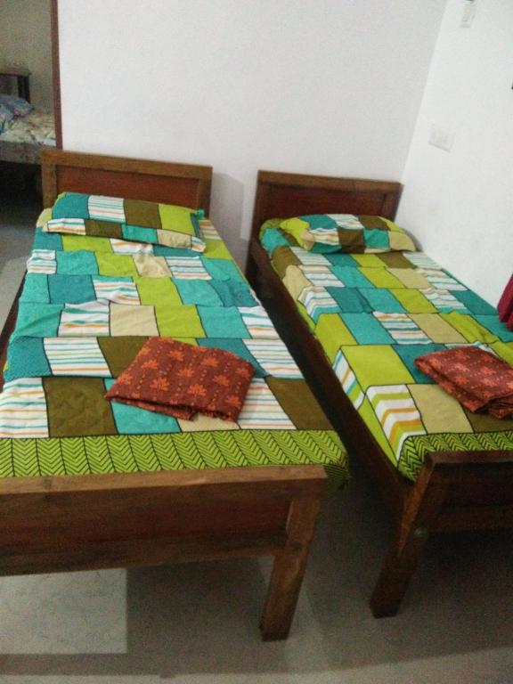 two beds sitting next to each other in a room at Nunu Homestay Guruvayoor in Guruvāyūr