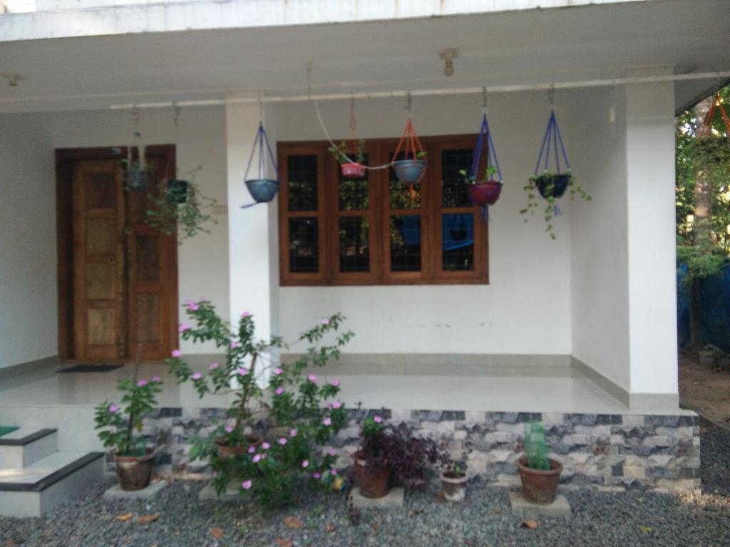 a house with potted plants in front of it at Nunu Homestay Guruvayoor in Guruvāyūr