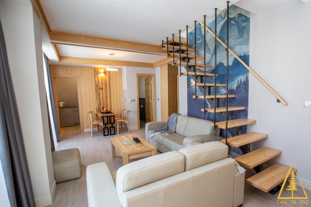 ein Wohnzimmer mit einem Sofa und einer Wendeltreppe in der Unterkunft Casa di Pino Eco Lodge in Žabljak