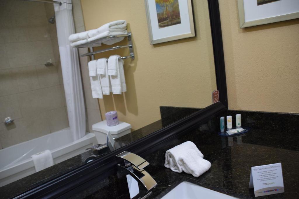 a bathroom with a sink and a mirror and towels at Quality Inn in Bracebridge