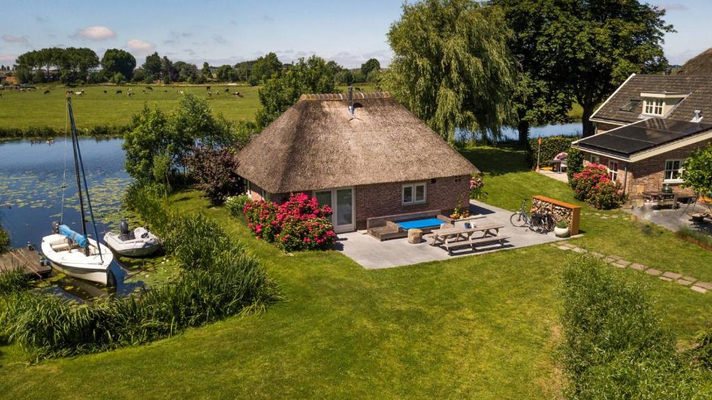 una vista aérea de una casa con un barco en el patio en Groeten uit Hoogmade - rural cottage en Hoogmade