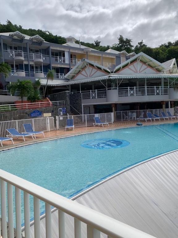 a swimming pool in front of a hotel at Studio Green Jungle in La Trinité