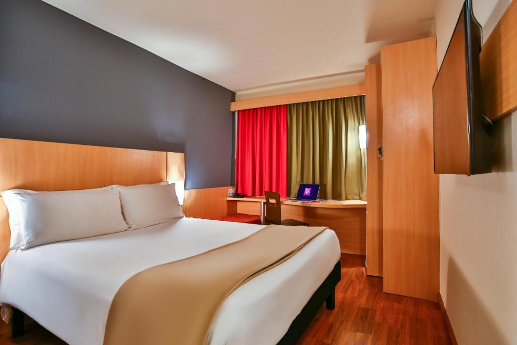 リオデジャネイロにあるイビス リオデジャネイロ ボタフォゴのベッドルーム1室(大型ベッド1台、赤い窓付)