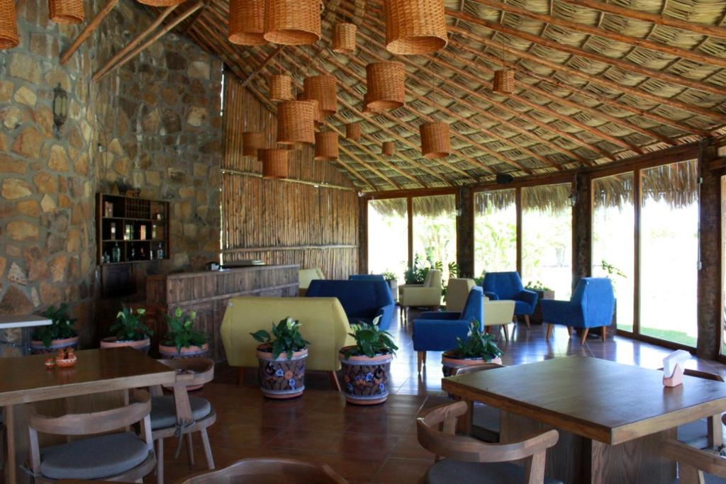 um restaurante com mesas e cadeiras num quarto em Hotel y Villas Los Pirules by Rotamundos em Villagrán