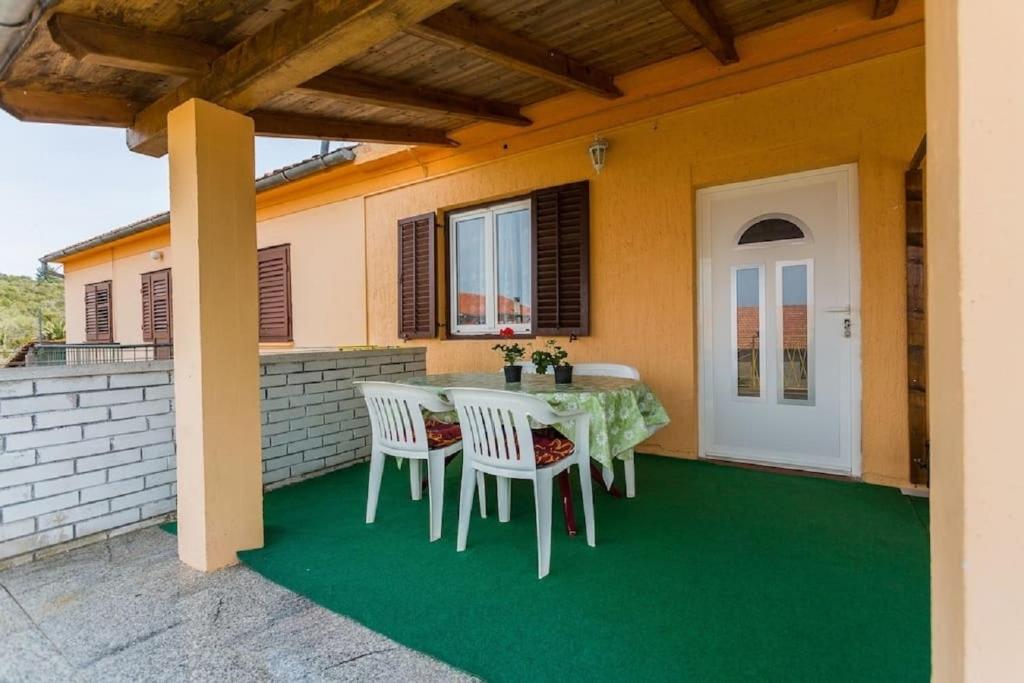 einen Tisch und Stühle auf der Terrasse eines Hauses in der Unterkunft Apartment Vesna - 100m from sea in Luka