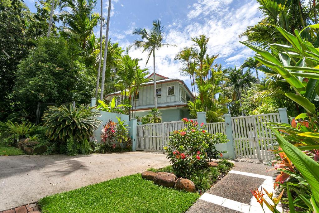una casa con una recinzione bianca in un cortile di Seascape Holidays Villas on Murphy Street a Port Douglas