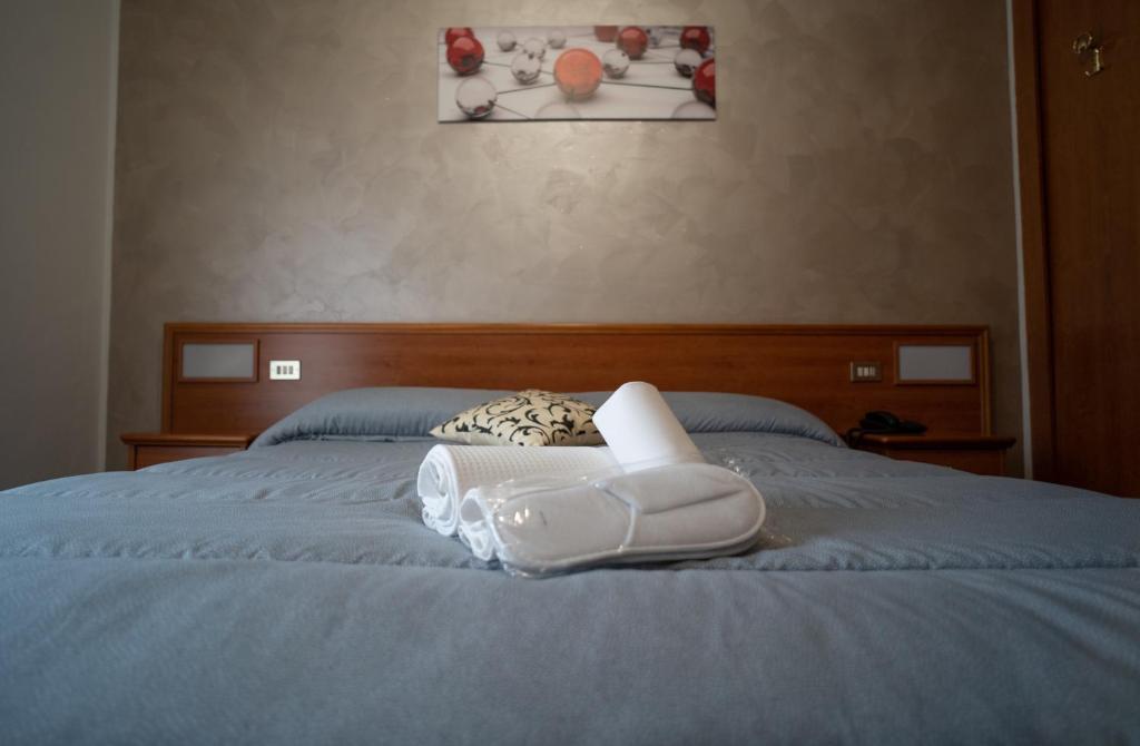 a bed with a pair of white shoes on it at Hotel Tre Monti in Popoli