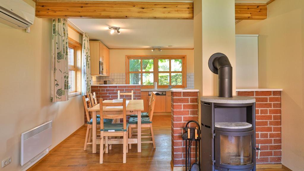 a kitchen and dining room with a wood stove at Heideröschen Park Heideröschen 9a in Zingst