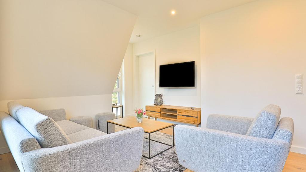 a living room with two chairs and a tv at Strandhaus Zingst Apartment 14 in Zingst