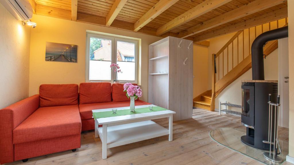 a living room with a red couch and a table at Heideröschen Park Heideröschen 5d in Zingst