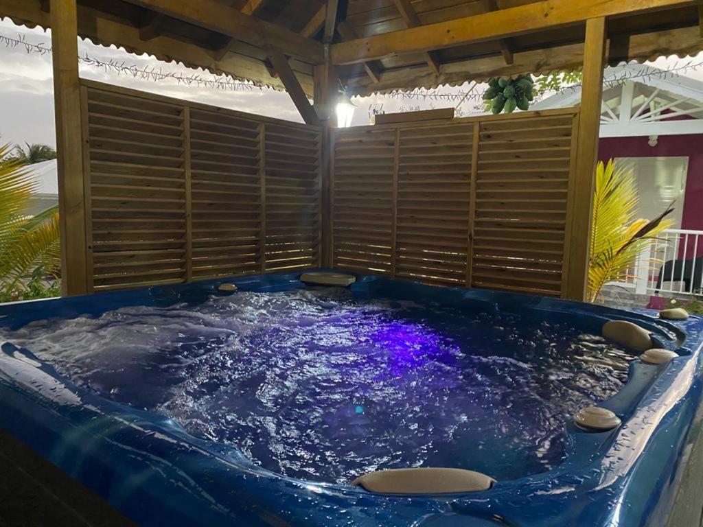 uma grande banheira de hidromassagem azul sentada sob um telhado em PARADIS DES SABLES em Les Galets