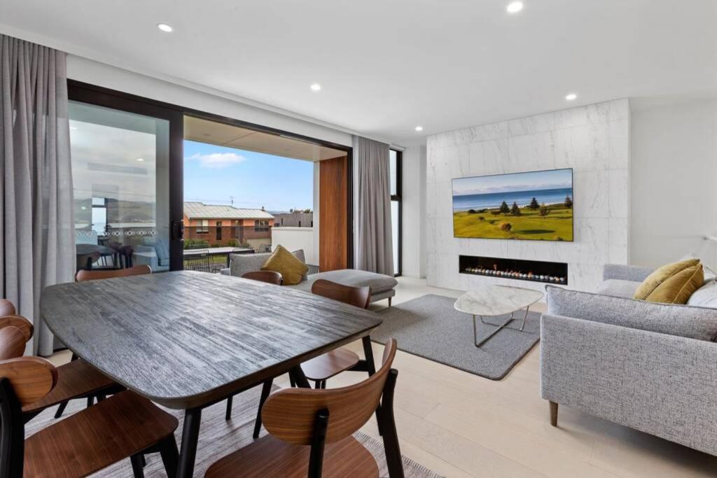 a living room with a table and a fireplace at luxurious 4 Bedroom Ocean View Holiday House in Apollo Bay