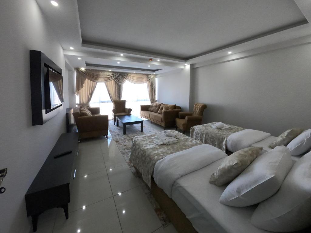 Habitación de hotel con 2 camas y sala de estar. en CNR OTEL Airport en Estambul