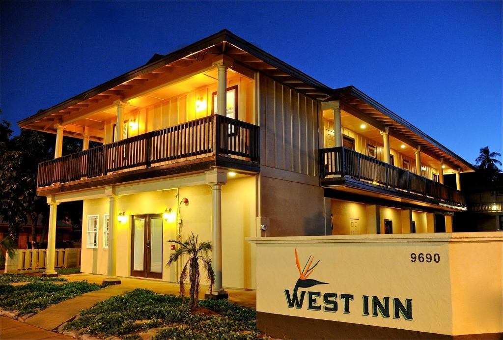 a house with a west inn sign in front of it at The West Inn Kauai in Waimea