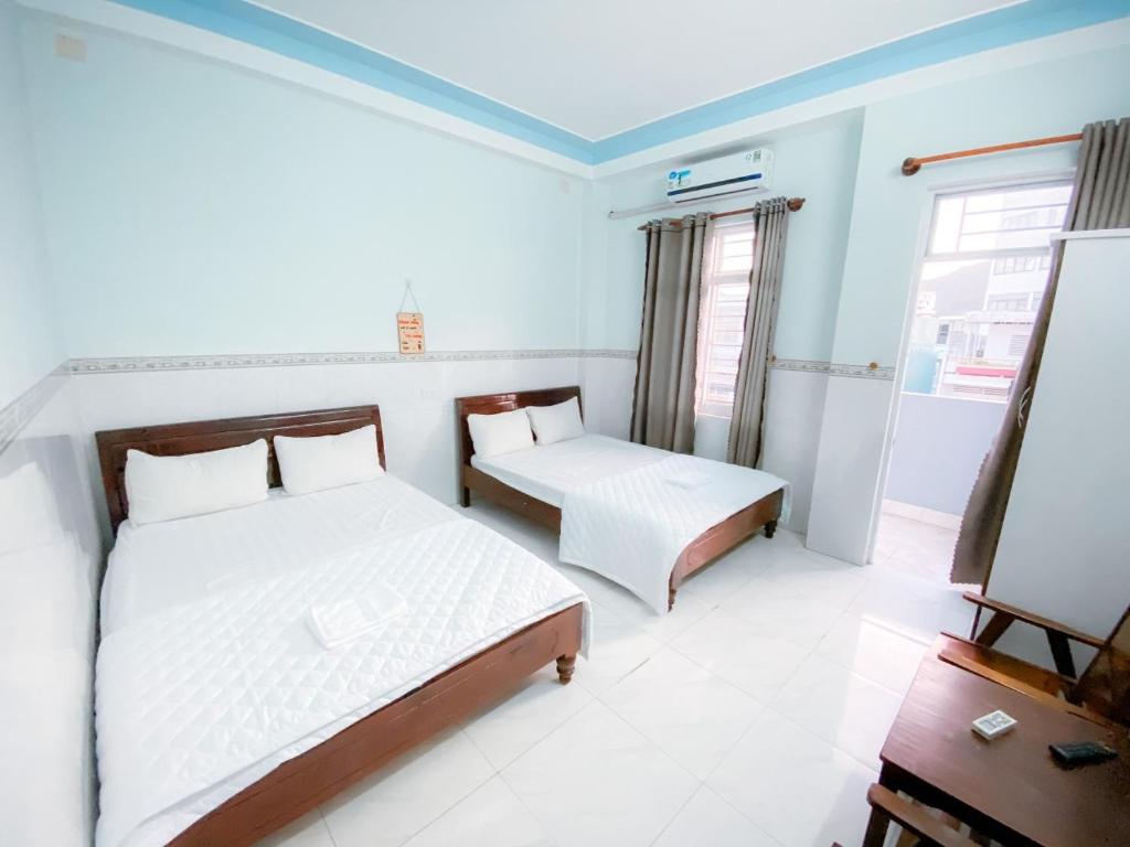 um quarto com 2 camas e uma janela em An Phát Motel em Quy Nhon