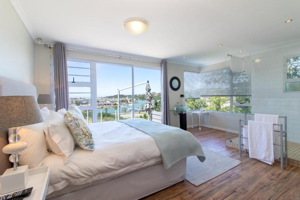 a bedroom with a large bed and a large window at Alfred View in Port Alfred