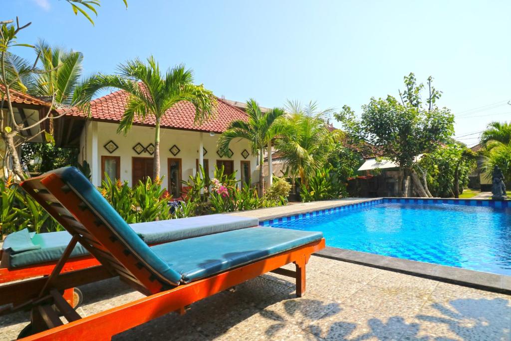 a chair sitting next to a swimming pool at Nyoman Guesthouse and Grill in Nusa Lembongan