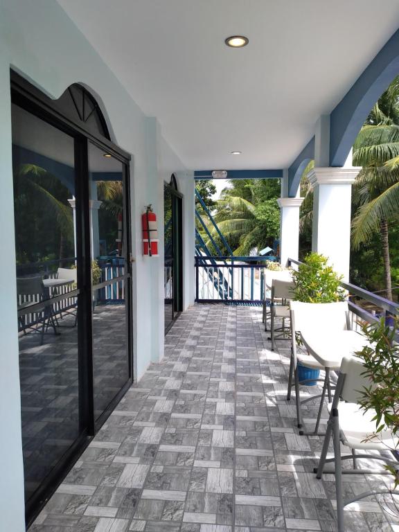 um pátio com cadeiras e mesas num edifício em Azulea Lodging House Oslob em Oslob