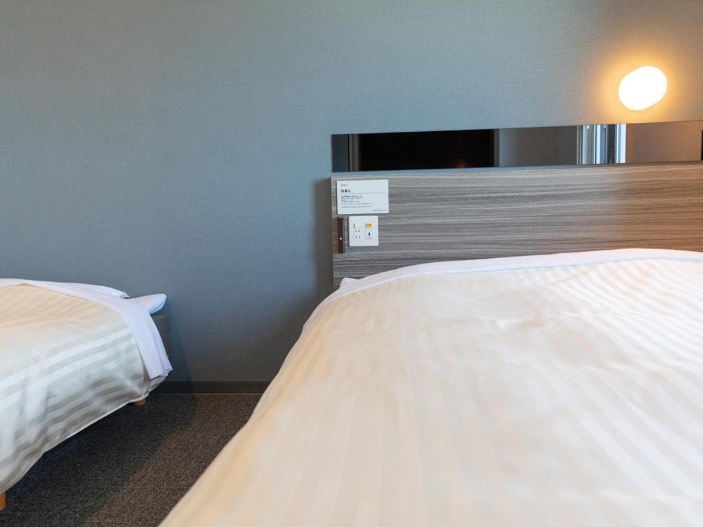 Postel nebo postele na pokoji v ubytování Super Hotel Ishikawa Nomineagari Smart Inter